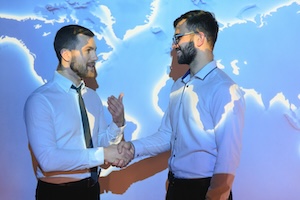 Handshake with map of the world in background.